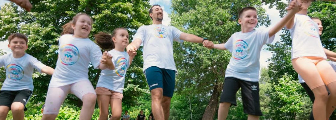 Group of joyful children playing outdoors with an instructor in a sunny park.